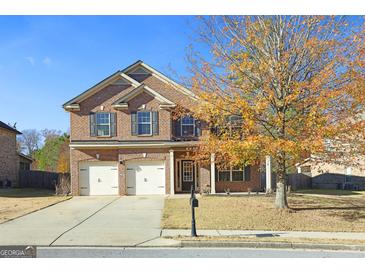 Two-story brick home with a two-car garage and landscaped yard at 960 Spanish Moss Trl, Loganville, GA 30052