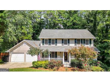 Two-story house with a large front porch, two-car garage, and landscaped yard at 577 Charing Cross Dr, Marietta, GA 30066