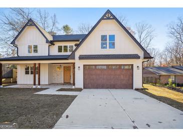 Two-story house with a brown garage door and white siding at 618 Bellemeade Dr, Marietta, GA 30008