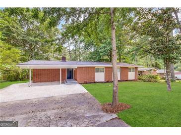 Front exterior of a single-Gathering home with a carport and a grassy yard at 3102 W Peek Nw Rd, Atlanta, GA 30318