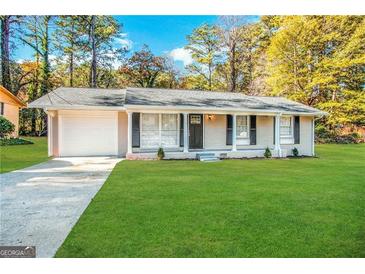 Charming renovated ranch home with a lush green lawn, driveway, and covered entryway at 1519 Pine Glen Cir, Decatur, GA 30035