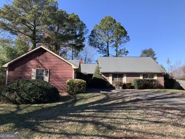 Charming two-story home with a driveway, front yard landscaping, and mature trees at 1603 Golf Link Dr, Stone Mountain, GA 30088