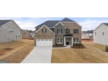 New construction home with a stone and brick exterior, and a two-car garage at 671 Edgar St, Hampton, GA 30228