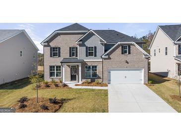 Charming two-story home with a brick and shingle exterior, front yard landscaping, and attached two-car garage at 1723 Goodwin, Hampton, GA 30228
