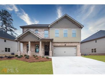 Attractive two-story home with a brick and siding exterior, front porch, and attached two-car garage at 659 Edgar Dr # 24, Hampton, GA 30228