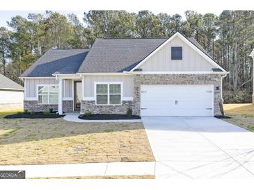 Craftsman style home with gray siding, brick accents, and a two-car garage at 3191 Azteca Way, Dacula, GA 30019