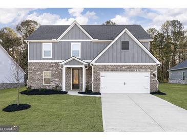 Two-story house with gray siding, brick accents, and a white garage door at 3402 Arabian Farm Ln, Dacula, GA 30019