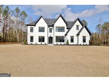 Two-story modern farmhouse with white siding, black accents, and a spacious lawn at 115 Grace Hope Dr, Brooks, GA 30205
