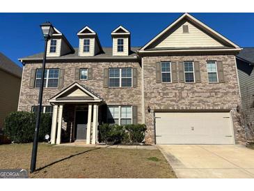 Charming brick two-story home featuring a covered entrance and two-car garage at 566 Mariposa Ln, Mcdonough, GA 30253