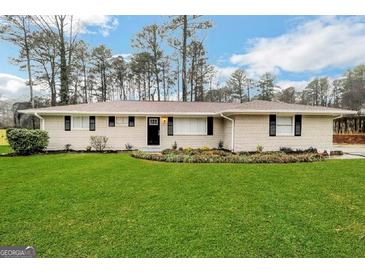 Ranch style home with brick facade, and a well-manicured lawn at 1908 Delowe Sw Pl, Atlanta, GA 30311