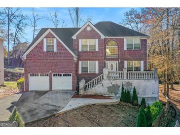 Brick two-story house with attached two-car garage and landscaping at 1799 Birkshire Rdg, Mcdonough, GA 30252