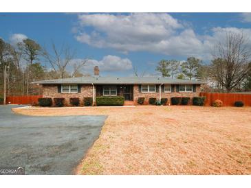 Brick ranch house with attached garage and large yard at 4924 River Rd, Ellenwood, GA 30294