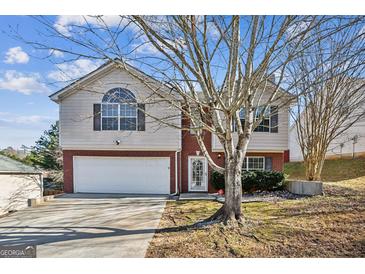 Two-story house with a brick and siding exterior, attached garage, and landscaping at 4626 Derby Loop, Fairburn, GA 30213