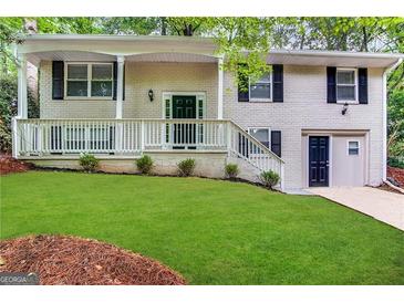 Brick ranch house with a green door, white railings, and a well-manicured lawn at 4436 Malibu Dr, Decatur, GA 30035