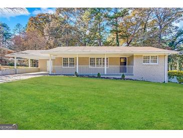 Ranch style home with brick facade, covered porch, and well-manicured lawn at 3975 Phylis Pl, Decatur, GA 30035