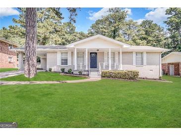 Ranch home with brick facade, covered porch, and a well-maintained lawn at 1914 Janet Ln, Decatur, GA 30035