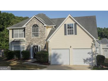 Two-story house with stone accents and a two-car garage at 30 Capeton Ct, Covington, GA 30016
