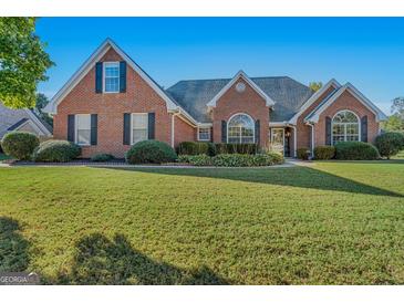 Brick house with a large front yard and landscaping at 1000 Maria Dr, Mcdonough, GA 30253