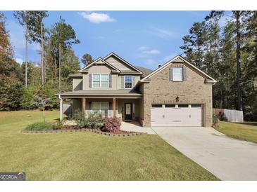 Two-story house with brick and siding, a covered porch, and a two-car garage at 540 Deadwood Trl, Locust Grove, GA 30248