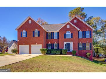 Brick two-story house with a two-car garage and landscaped lawn at 3071 Springfair Trott, Lithonia, GA 30038