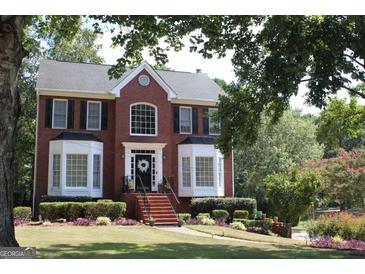 Brick two-story house with landscaped lawn and walkway at 9342 Carillon Ct, Jonesboro, GA 30236