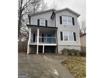 Two-story house with gray siding, a teal door, and a driveway at 1438 Rome Nw Dr, Atlanta, GA 30314