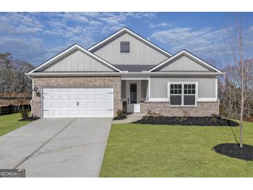 Brick and board-batten house with a two-car garage and landscaped lawn at 3452 Arabian Farm Ln, Dacula, GA 30019