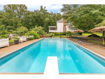 Inviting rectangular pool with diving board and patio furniture at 2398 Maddox Rd, Buford, GA 30519