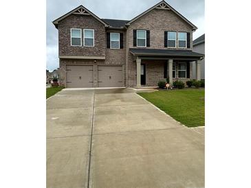 Two-story brick home with two car garage and landscaping at 163 Kingfisher Walk, Covington, GA 30014