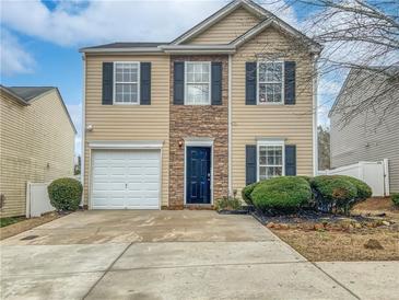 Two-story house with beige vinyl siding, stone accents and a two-car garage at 212 Silver Ridge Dr, Dallas, GA 30157