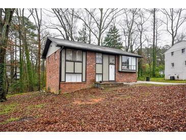 Brick ranch home with a landscaped yard and driveway at 340 Sir Richard Ct, Jonesboro, GA 30236