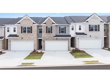 Three-unit townhome building with brick and neutral colors at 2728 Honey Locust, Loganville, GA 30052