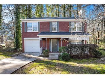 Brick home with attached garage and landscaping at 6674 Eastbriar Dr, Lithonia, GA 30058