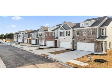 Exterior view of townhomes with brick and siding at 167 Belldown Ct, Mcdonough, GA 30253