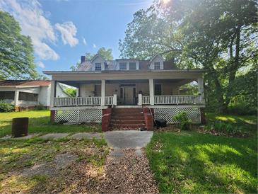 Charming house with wrap-around porch and established landscaping at 688 Main St, Whitesburg, GA 30185
