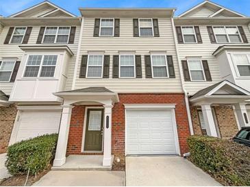 Beige three-story townhome with brick base and attached garage at 6756 Blackstone Pl # 6, Mableton, GA 30126