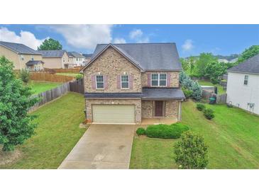 Two-story brick home with attached garage and landscaped yard at 3203 Puritan Way, Mcdonough, GA 30252