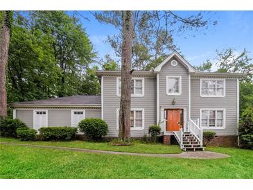 Two-story house with gray siding, a brick foundation, and a landscaped yard at 2848 Creekwood Dr, Snellville, GA 30078