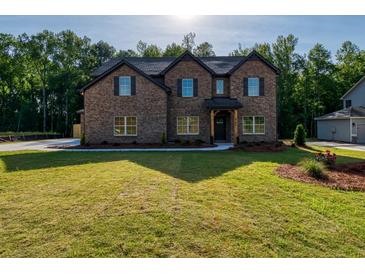Brick two-story house with a covered front porch and landscaping at 557 Saltbox Ln, Mcdonough, GA 30252