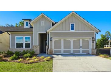 Two-story house with gray siding, three-car garage, and landscaped front yard at 2013 Ripple Park Bnd, Canton, GA 30114