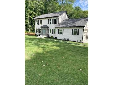 Two story house with white siding, gray roof, and landscaping at 4604 Shumart Dr, Snellville, GA 30039