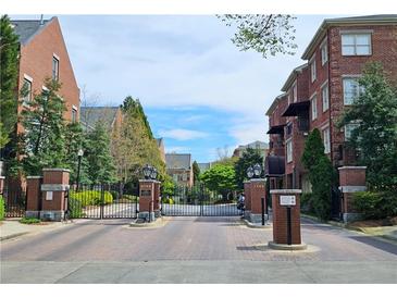 Brick gated community entrance with landscaping and street view at 1735 Peachtree Ne St # 210, Atlanta, GA 30309