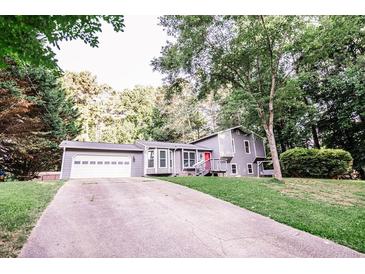 Gray house exterior with a white garage door and red front door at 377 Mill Ridge Way, Lawrenceville, GA 30046