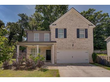 Two-story brick home with a front porch and driveway at 2248 Annes Lake Cir, Lithonia, GA 30058