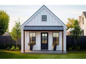 Charming farmhouse-style home with a black metal roof and white siding at 24 Cheney St, East Point, GA 30344