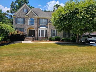 Brick house with manicured lawn and mature trees in front at 9904 Hamilton Dr, Douglasville, GA 30135