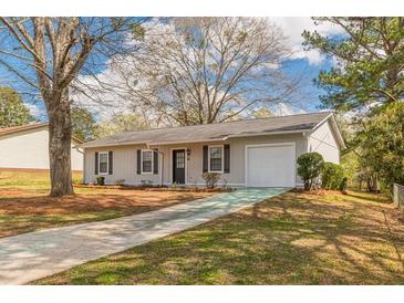 Cozy ranch home with a white exterior, black shutters, and driveway at 105 Adrian Dr, Stockbridge, GA 30281
