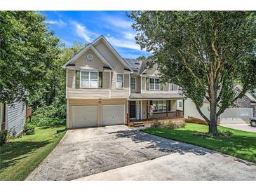 Two story house with beige siding, green shutters, and a two car garage at 362 Covington Dr, Hiram, GA 30141