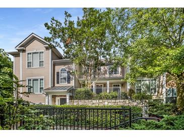 Tan two-story townhome with stone accents and a landscaped front yard at 2400 Cumberland Se Pkwy # 522, Atlanta, GA 30339