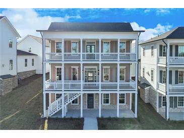 Charming three-story home with double-decker balconies and landscaped yard at 1274 Six Sisters St, Dacula, GA 30019